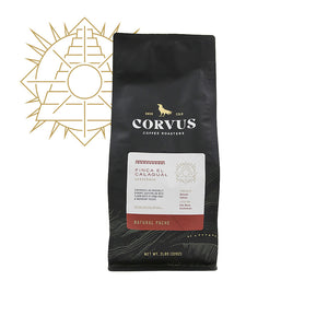 A bag of Corvus Coffee, Finca El Calagual coffee beans with a label indicating the product name and variety. The packaging is predominantly black with gold and white details.