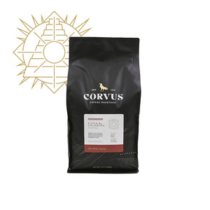 A bag of Corvus Coffee, Finca El Calagual coffee beans with a label indicating the product name and variety. The packaging is predominantly black with gold and white details.