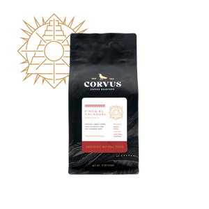 A black bag of Corvus Coffee Roasters Finca El Calagual Supremo coffee, displayed on a clean white background with a gold geometric sun logo overlay in the upper left corner.